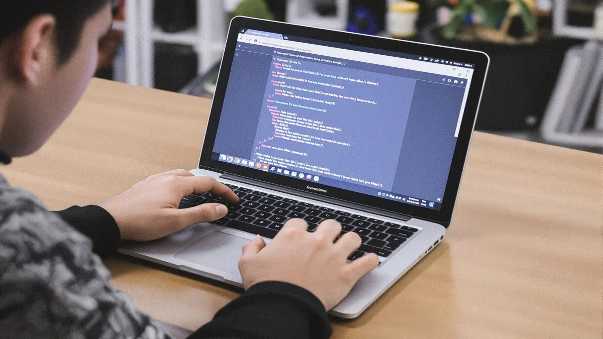 Personne tapant du code sur un ordinateur portable.